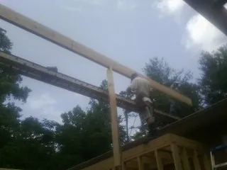 Carpenter setting a ridge beam over a new addition frame — Ice Dam Removal by Roofing Brothers in Cliffside Park