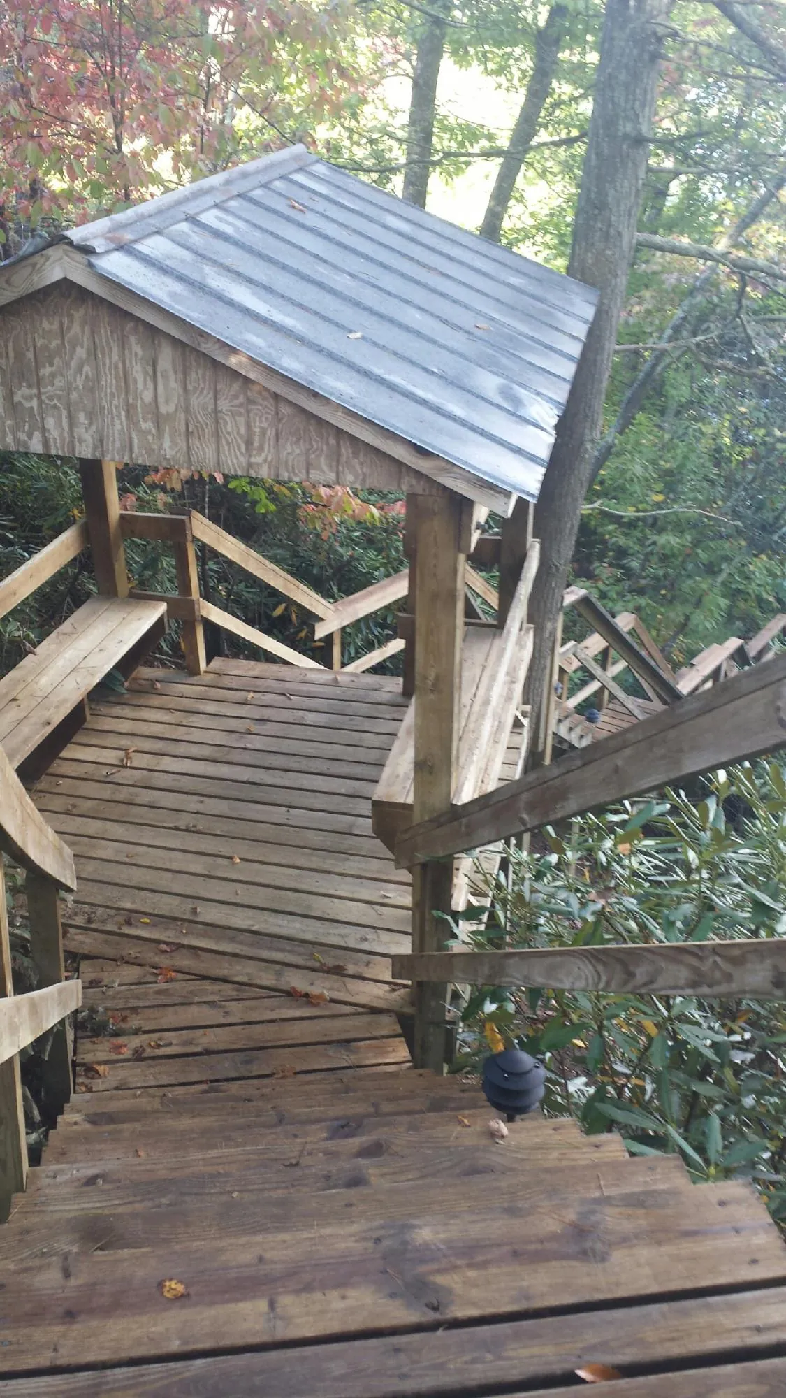 Metal roofed shelter over wooden steps on a wooded walkway — Skylight Repair & Installation work by our crew in Cliffside Park