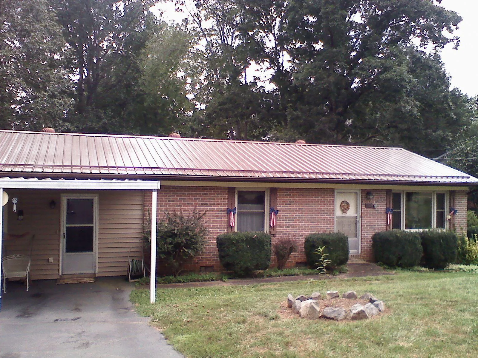 Bronze metal roof and carport on a brick ranch home — Roof Repair work by our crew in Cliffside Park